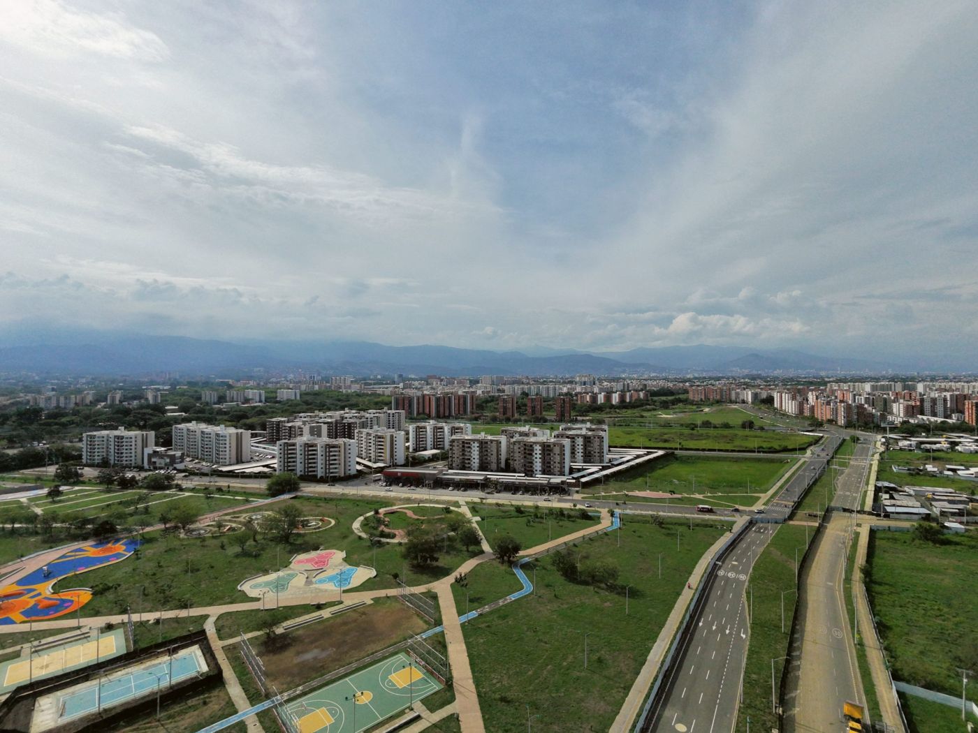 Avenida, parque y conjuntos residenciales con la cordillera al fondo